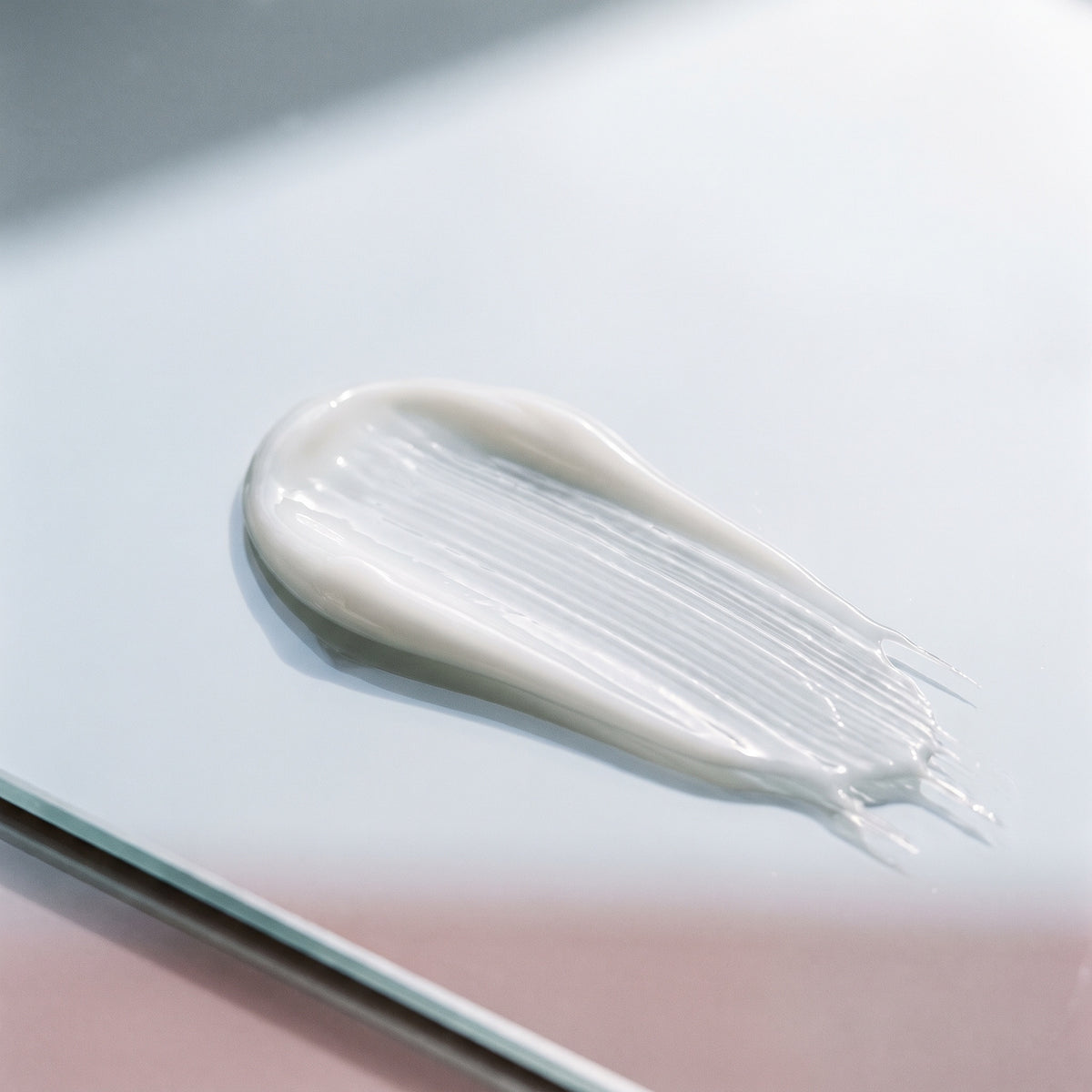 Illustrative skincare cream texture on a pale glass surface